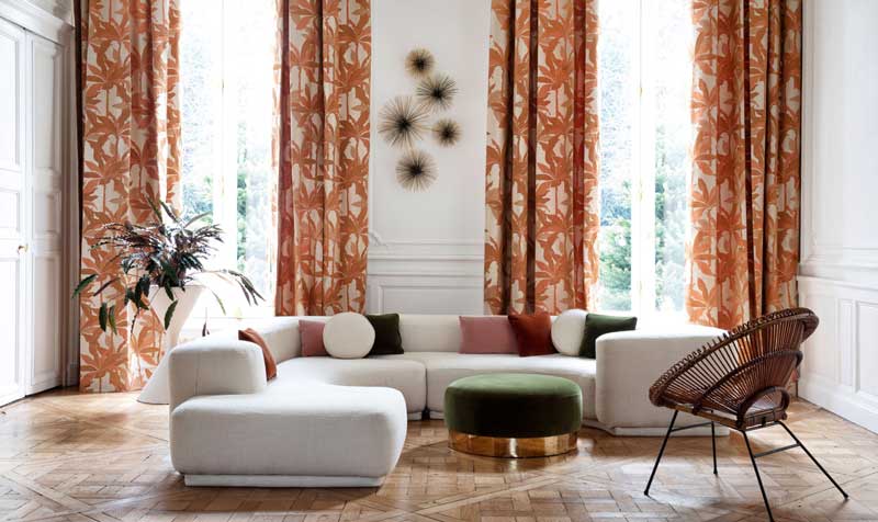 Salón decorado con sofá rinconero en tapicería neutra