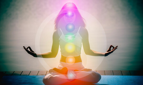 Mujer joven en meditación de yoga con siete chakras y símbolos Yin Yang
