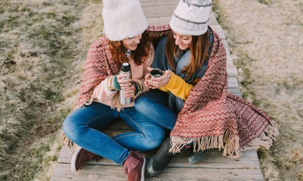 mujeres abrigadas tomando un café caliente