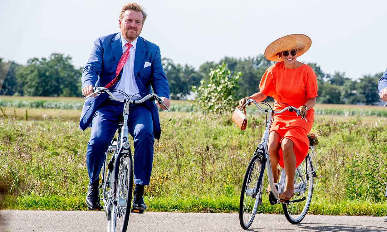 Máxima de Holanda con taconazo, bolso y pamela en bicicleta